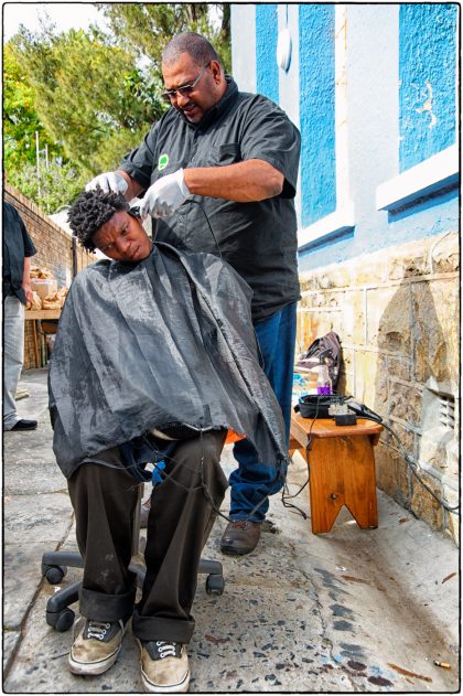 Fieldworker Mark Williams cutting hair. 