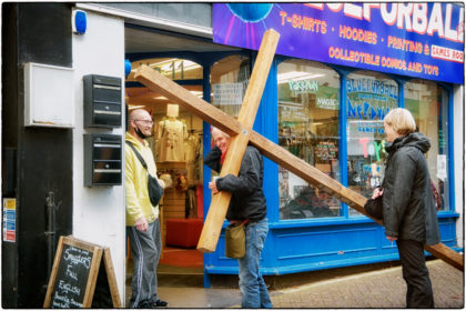 Carrying a wooden cross representing Jesus. 